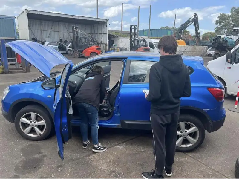 Xanthe is inspecting a vehicle for breaking with a work experience student. Xanthe is inspecting a vehicle for breaking with a work experience student.: Swipe To View More Images